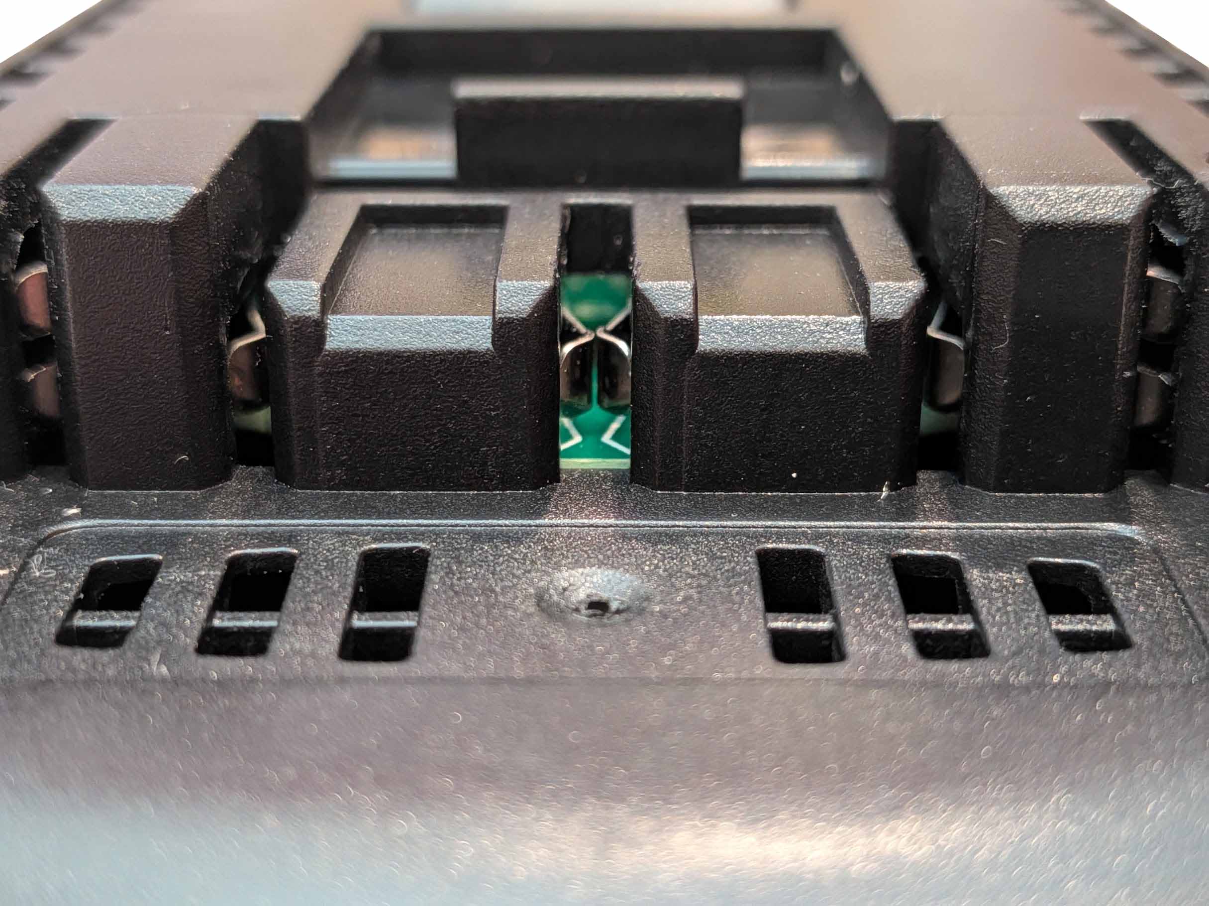 DeWalt 20V MAX to Bosch 18V GBA (Blue) battery adapter - close-up of the Bosch tool-side terminal slots and copper contacts