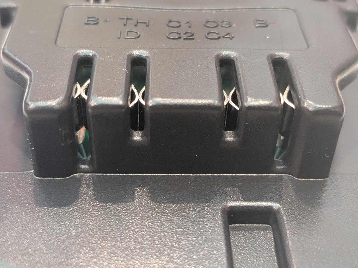 Ozito 18V PXC to DeWalt 20V MAX battery adapter - close-up of the DeWalt tool-side terminals with moulded contact markings